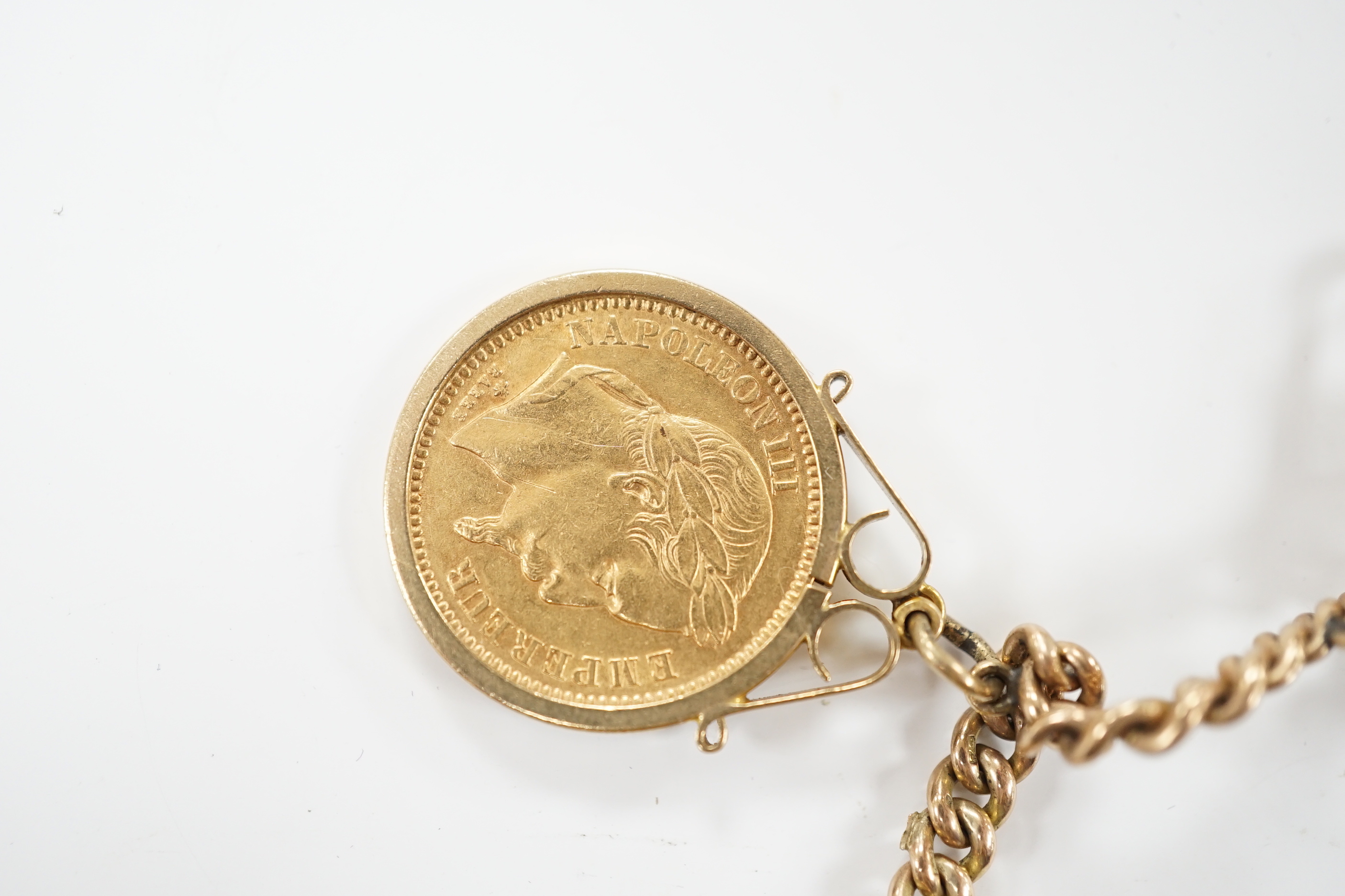 A 9ct gold curblink chain hung with fifteen assorted charms including a 1906 sovereign and an 1865 20 francs coin, gross 80.8 grams